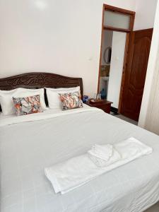 a white bed with two towels on top of it at Beytumn Executive Apartment in Ruiru
