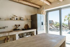 a kitchen with a table and a large window at Casa Arim in Orosei