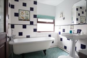 a bathroom with a white tub and a sink at Hen Gamdda Fawr in Llanallgo +101 photos