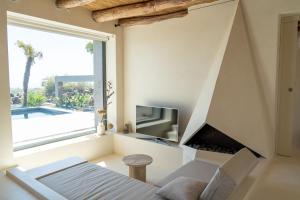 a living room with a large window and a tv at Casa Arim in Orosei