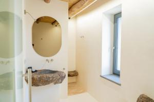 a bathroom with a stone sink and a mirror at Casa Arim in Orosei +31 photos