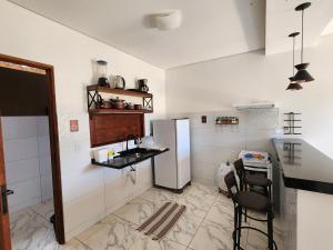 a kitchen with a refrigerator and a table and chairs at Lar de verão casa 01 in Barra de São Miguel