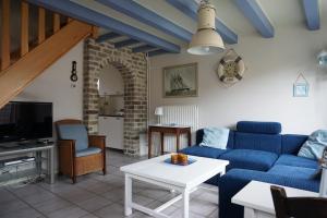 a living room with a blue couch and a table at Kustverhuur, Nieuwesluisweg 6A in Breskens