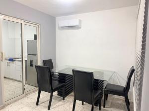 a dining room with a glass table and black chairs at Colorín RB in La Paz +5 photos