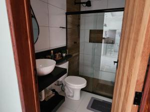 a bathroom with a toilet and a sink and a shower at Lar de verão casa 01 in Barra de São Miguel