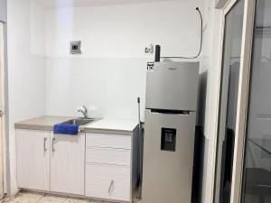 a white kitchen with a refrigerator and a sink at Colorín RB in La Paz