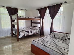 two bunk beds in a room with windows at Finca Las Vegas in Aguazul