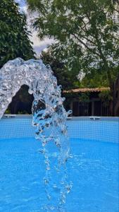 a water fountain in front of a swimming pool at Finca Las Vegas in Aguazul