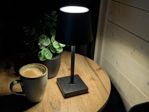 a lamp and a cup of coffee on a table at Tiny House WaldSEEle in Stuer