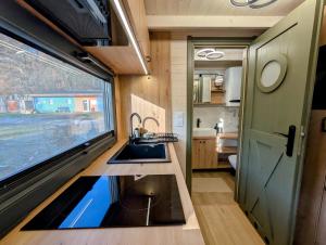a kitchen in a tiny house with a sink and a window at Tiny House WaldSEEle in Stuer