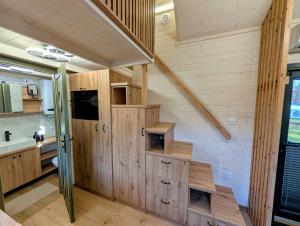 a kitchen with wooden walls and stairs in a house at Tiny House WaldSEEle in Stuer +22 photos
