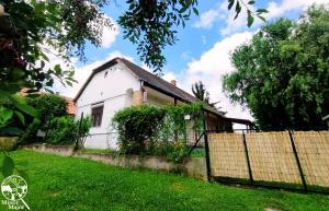 a white house with a fence in a yard at Minor Major Vendégház in Somogyacsa