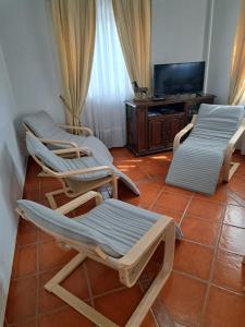 a room with three lounge chairs and a television at Casa Azélia e Albino in Aves