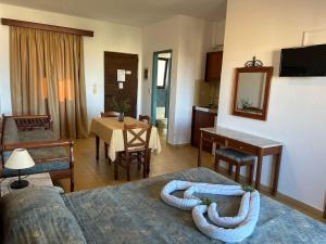 a living room with a couch and a dining room at Areti Aparthotel in Áptera