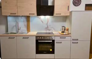 a kitchen with white cabinets and a sink and a stove at Your Perfect Escape to Relax in Sipbachzell