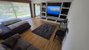 a living room with a couch and a flat screen tv at Your Perfect Escape to Relax in Sipbachzell