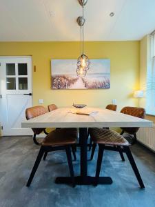a dining room with a table and chairs at It Winkelhûs in Terschelling