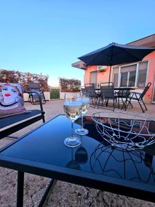 a table with two wine glasses on top of it at Stella-Guesthouse - Terrazzo privato e relax vicino Siracusa in Solarino