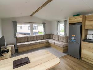 a living room with a couch and a refrigerator at The Foxy Cobbler in Kingsbridge