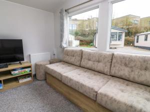 a living room with a couch and a large window at The Foxy Cobbler in Kingsbridge