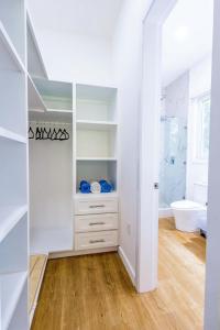 a bathroom with a white closet with a toilet and a tub at Blue Roatan Resort in West Bay