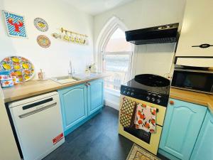 a kitchen with blue cabinets and a stove top oven at Langdale Loft - Whitby in Whitby +6 photos