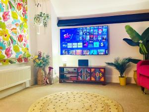 a living room with a tv and a red chair at Langdale Loft - Whitby in Whitby