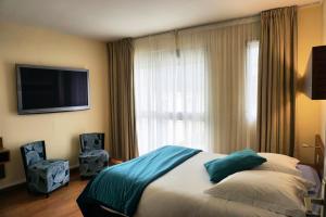 a bedroom with a bed and a large window at Hotel Ker Vennaik in Bénodet