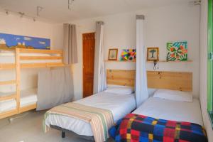two beds in a room with two bunk beds at La Palma Hostel by Pension Central in Fuencaliente de la Palma