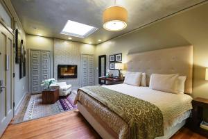 a bedroom with a large bed and a television at The Campbell Hotel in Tulsa +55 photos