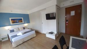 a hotel room with a bed and a television at Flat Vila Mariana Ibirapuera (Apto 1005) in São Paulo