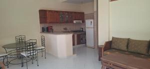 a kitchen with a refrigerator and a table and chairs at Le tout confort face à la mer in Sidi Ifni