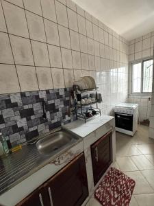 a kitchen with a sink and a stove at Appartement moderne et épuré in Bonabéri