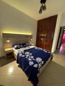 a bedroom with a bed with a blue comforter at Appartement moderne et épuré in Bonabéri +2 photos