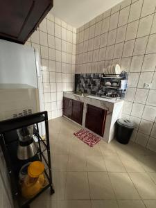 a kitchen with a stove and a refrigerator at Appartement moderne et épuré in Bonabéri