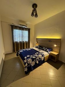 a bedroom with a large bed and a window at Appartement moderne et épuré in Bonabéri
