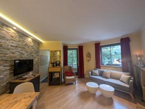 a living room with a couch and a tv at Chalet Jägerstieg in Braunlage
