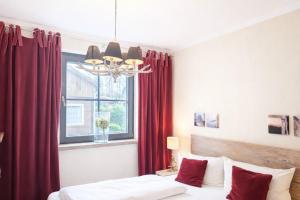 a bedroom with a bed and a window with red curtains at Chalet Jägerstieg in Braunlage