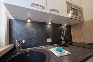 a kitchen counter with a sink and a microwave at Chalet Jägerstieg in Braunlage +15 photos