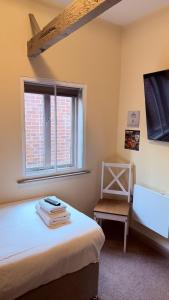a bedroom with a bed and a window and a chair at Grant House in Boston