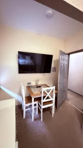 a room with a table and two chairs and a tv at Grant House in Boston
