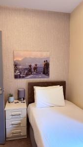 a bedroom with two beds and a nightstand with a picture on the wall at Grant House in Boston