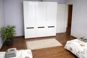 a bedroom with white cabinets and a rug at Apartament Azyl in Przemyśl