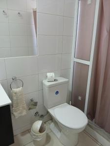 a white bathroom with a toilet and a shower at Casa Cómoda en La Cruz Quillota in La Cruz