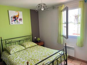 a bedroom with a bed with green walls and a window at La Dyva 2 in Saint-Jean-de-Monts