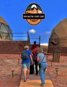 a group of people walking down a path with luggage at RUM MARTiN BUBBLES lUXURY CAMP in Wadi Rum