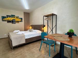 a bedroom with a bed and a table and a table and chairs at Tina House in Siculiana