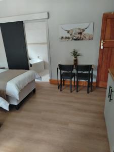 a bedroom with a bed and a table and chairs at KarooRus in Burgersdorp