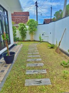 a garden with stepping stones in front of a house at Ancestral Aura in Negombo