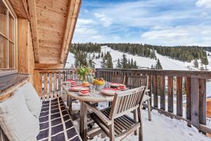 a wooden deck with a table and chairs on a ski slope at Chalet Lachtal in Lachtal